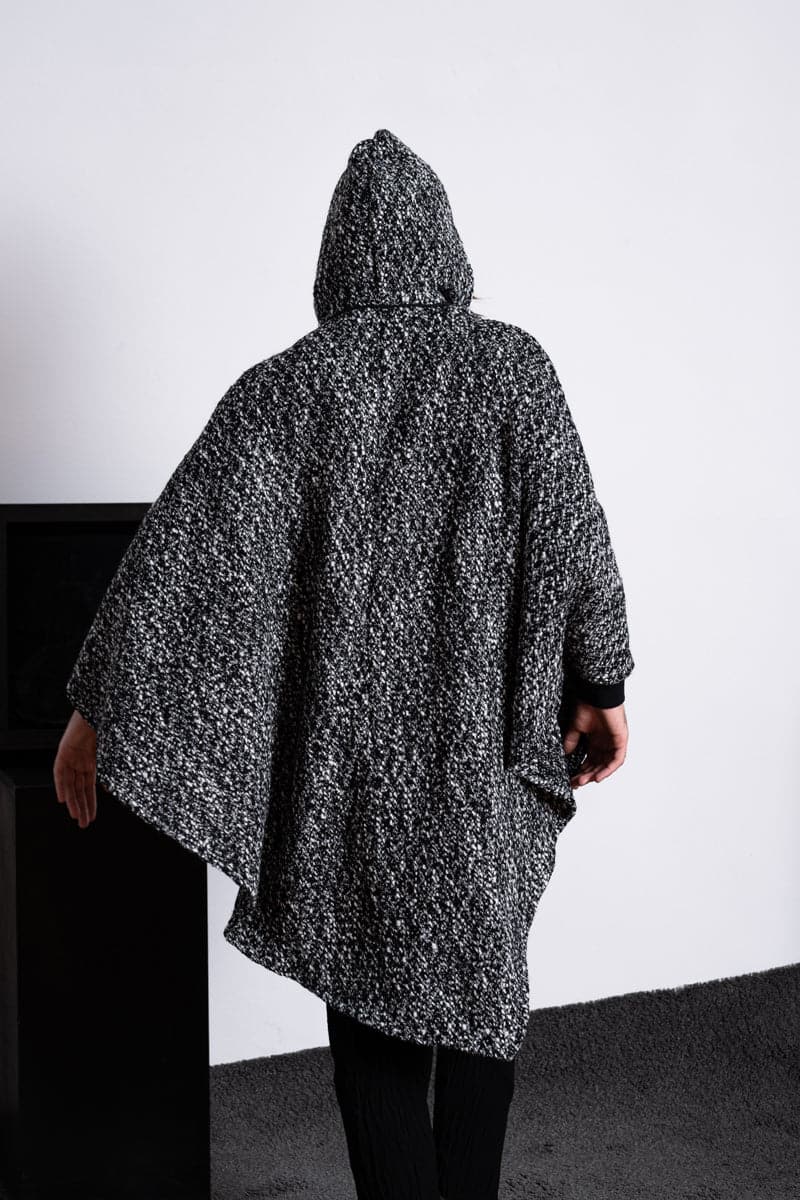 eigensinnig wien | Persephone | Extravagantes und weites Cape mit Kapuze aus Wolle in schwarz/weiß
