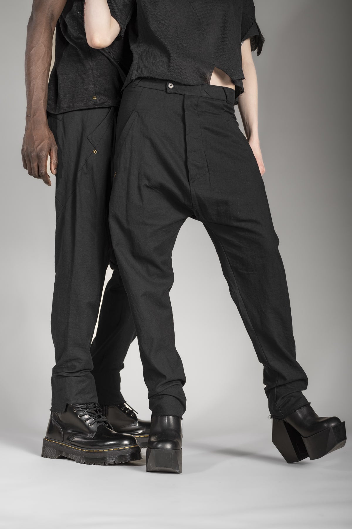 Designer Drop Crotch Pants in Schwarz, die ein Mann und eine Frau tragen im eigensinnig wien