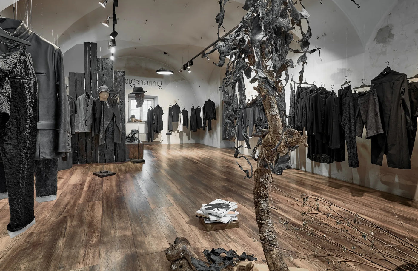 Innenraum des eigensinnig Stores in Wien mit schwarzer Designermode und skulpturaler Raumgestaltung