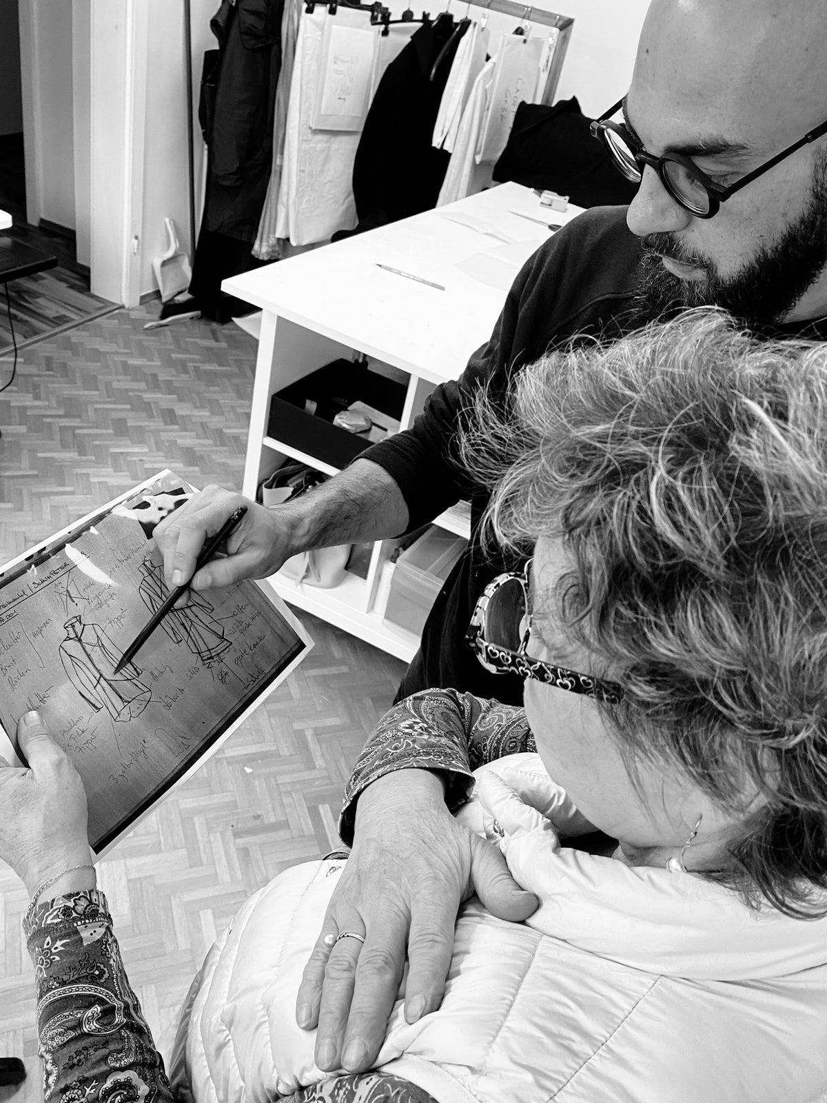 Designer und Schneiderin arbeiten gemeinsam an einem Schnittmuster im Atelier